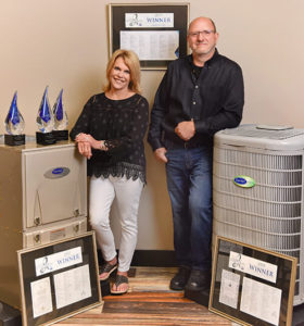 Man and woman standing next to Carrier unit and Carrier Cooling Awards