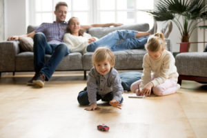 Child playing on floor with two parents watching